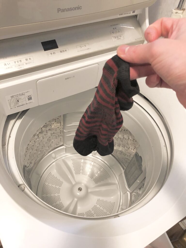 靴下を洗濯機へ入れる画像